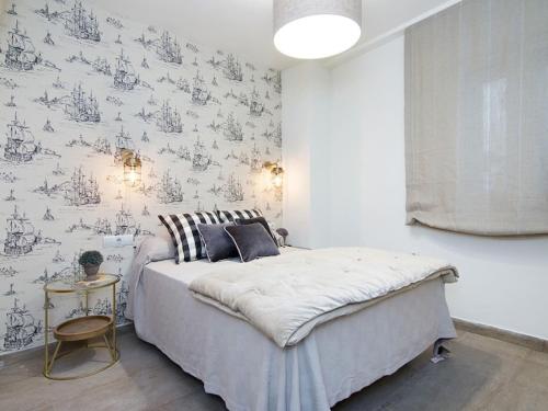 a bedroom with a bed and a wall with wallpaper at Chezmoihomes Cathedral Apartment in Granada