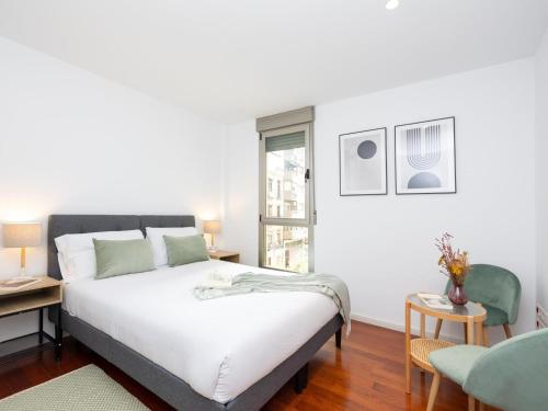 1 dormitorio con cama blanca y ventana en San Anton Boutique Terrace, en Granada