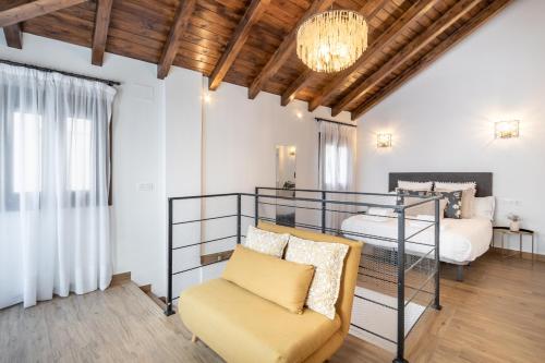 a bedroom with a bed and a chair in a room at Casa Naranjos de San Matías in Granada