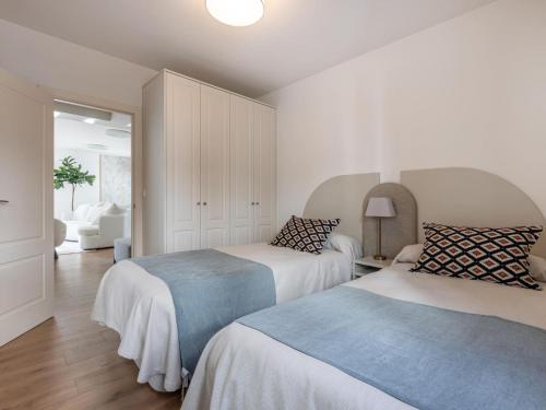 グラナダにあるAlhambra Dreamの白い壁とウッドフロアの客室で、ベッド2台が備わります。