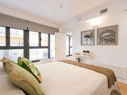 a bedroom with a large bed and large windows at Chezmoihomes Plaza Nueva Luxury in Granada