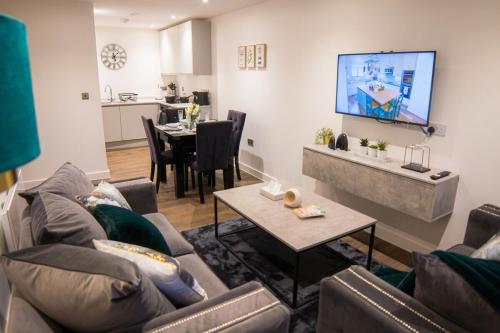 uma sala de estar com um sofá e uma televisão na parede em Luxury Stay 5 mins to Manchester city centre! em Manchester