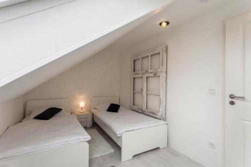 two beds in a white room with a staircase at Industrial in Schloß Holte-Stukenbrock