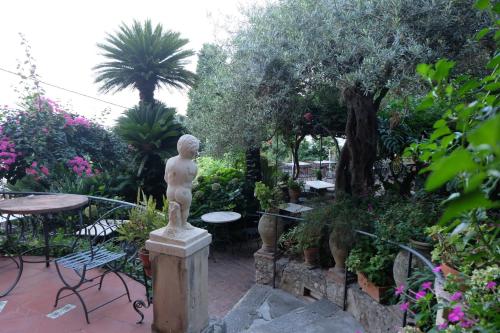 a garden area with a fountain and a bench at Hotel Villa Nettuno in Taormina