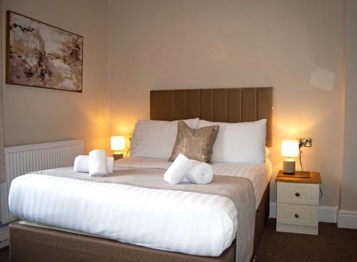 a bedroom with a large bed with towels on it at Hotel No5, Beachfront with Free Private Car Park in Llandudno