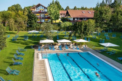 an overhead view of a swimming pool with chairs and umbrellas at Hotel Rottaler Hof in Bad Birnbach