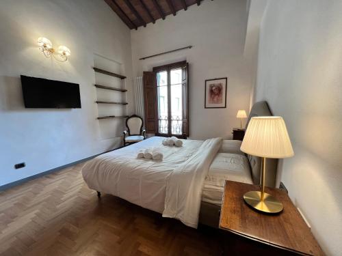 a bedroom with a bed and a table with a lamp at Baroni Cortelli Apartments Firenze in Florence
