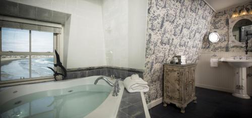 a bathroom with a tub and a sink at The Chanler at Cliff Walk in Newport