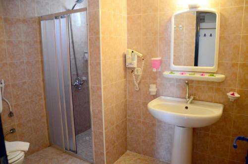 een badkamer met douche, wastafel en spiegel bij Sunpoint Hotel Bodrum in Bodrum City