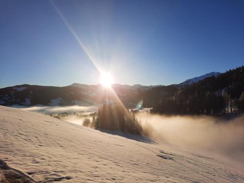 a view of the sun rising over a fog covered mountain at Sonnenappartements Madlstatthof in Wildschönau