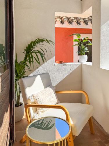 a chair and a mirror in a room with plants at Villa La Petite Etoile in Torre delle Stelle
