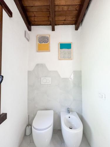 a white bathroom with a toilet and a sink at Villa La Petite Etoile in Torre delle Stelle