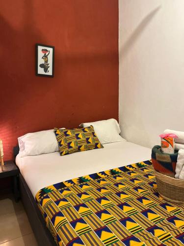a bedroom with a bed with a colorful blanket on it at African Treasure Beach Resort in Kokrobite