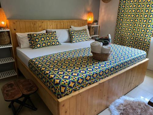 a bedroom with a large bed with a wooden frame at African Treasure Beach Resort in Kokrobite