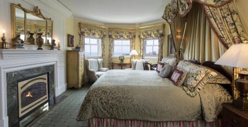 a bedroom with a king sized bed and a fireplace at The Chanler at Cliff Walk in Newport