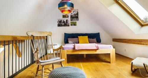 フライブルク・イム・ブライスガウにあるSt Georgen Ferienwohnung 1のベッドと椅子付きの屋根裏部屋