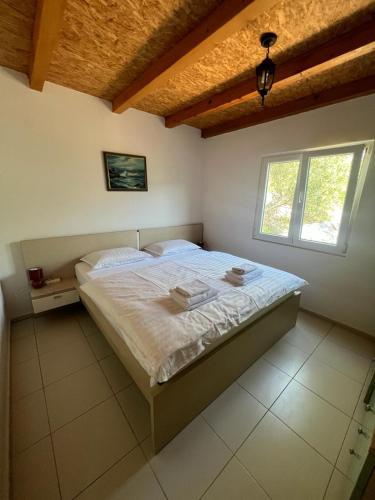 1 dormitorio con cama y ventana en Kuća za odmor Buba, en Murter