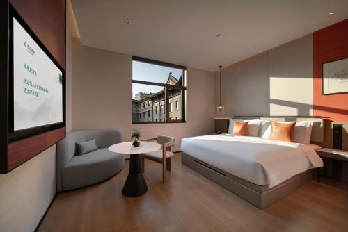 a hotel room with a bed and a tv at SSAW Garden Hotel Beijing in Beijing