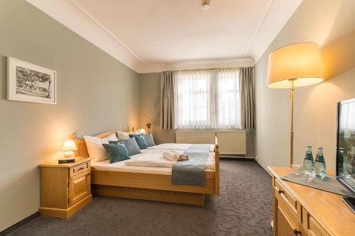 een slaapkamer met een groot bed met blauwe kussens bij Hotel Roß in Zwönitz