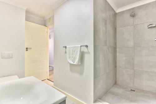 a white bathroom with a shower and a toilet at 636 Newlands Peak Luxury Apartment in Cape Town