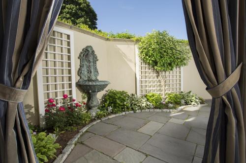 a garden view through the curtains of a courtyard at The Chanler at Cliff Walk in Newport