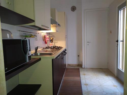 una cucina con lavandino e piano cottura di La Baia Apartments by My Home Apulia a Torre Lapillo
