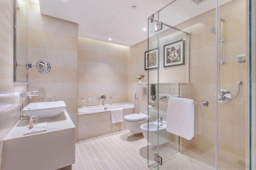 uma casa de banho com um WC, um lavatório e um chuveiro em Spacious Studio Apartment in Hyatt Regency Dubai Creek Heights by the S Holiday Homes em Dubai