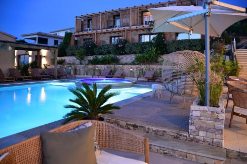une piscine avec des chaises et un parasol dans l'établissement Hotel Palazzu & SPA - Adult Only, à Galéria