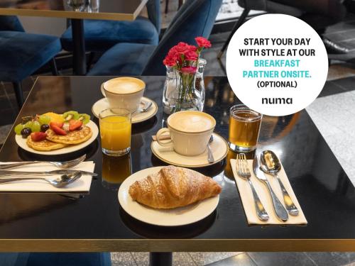 a table topped with plates of food and cups of coffee at Numa Prague Republika in Prague