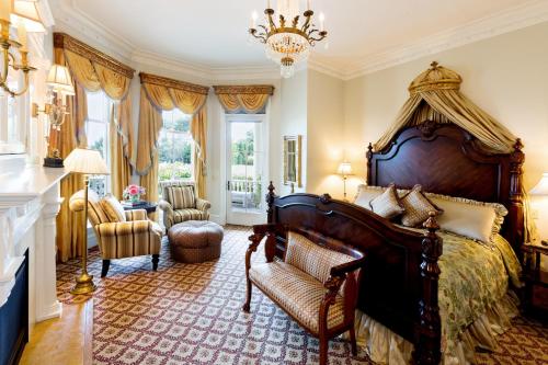 a bedroom with a large bed and a chandelier at The Chanler at Cliff Walk in Newport