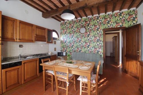 a kitchen with a wooden table and chairs in a room at Corte Tommasi Residence in Orentano
