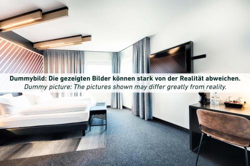 um quarto de hotel com uma cama e uma secretária em B&B HOTEL Magdeburg-Barleben em Barleben