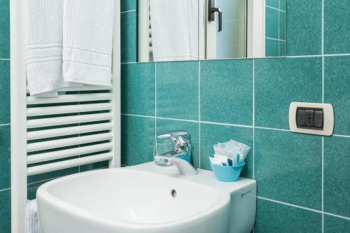 baño con lavabo blanco y azulejos azules en Hotel Cristallo en Rímini