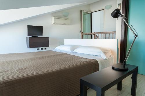una camera con letto e tavolo con lampada di Hotel Cristallo a Rimini
