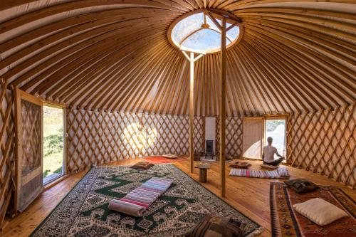 a man in a yurt with a man sitting in a room at La Ferme de Beauté in Chateauroux-les-Alpes