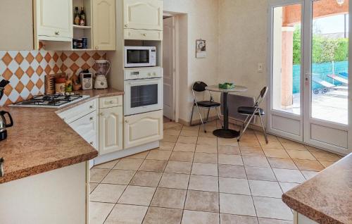 une cuisine avec des appareils électroménagers blancs et une table avec une table dans l'établissement 5 Bedroom Stunning Home In Les Arcs, aux Arcs-sur-Argens