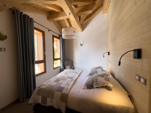 a bedroom with a bed with pillows on it at le A by neige et roc in Morzine