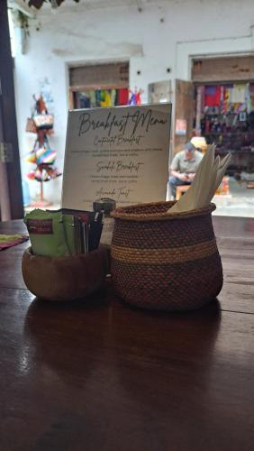 a basket of items sitting on a table with a sign at Emerald Palm Boutique Hotel in Zanzibar City
