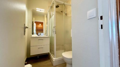 une salle de bain avec toilettes et douche en verre dans l'établissement Studio avec balcon, vue panoramique sur la baie, au Crotoy