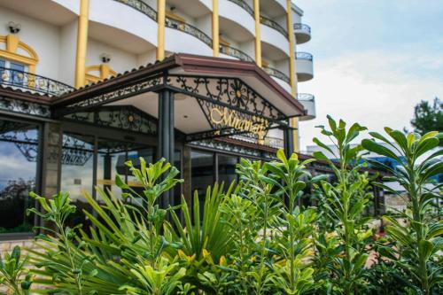 un edificio con plantas verdes delante de él en Hotel Miramare, en Vodice