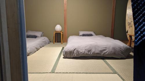 a room with two beds and a table at Yukiumi Furano in Furano