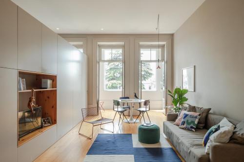 - un salon avec un canapé et une table dans l'établissement Baumhaus Serviced Living - Art & Design Apartments, à Porto