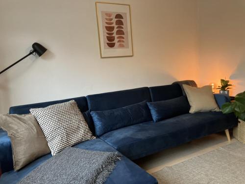 a blue couch with pillows in a living room at 3 bedroom house in Bedminster near Wapping Wharf in Bristol