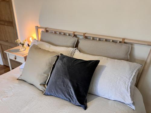 a bed with four pillows on top of it at 3 bedroom house in Bedminster near Wapping Wharf in Bristol