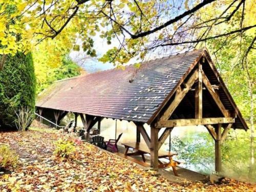 a wooden pavilion with a roof on the side of a river at B&B HOTEL Chartres Centre Cathédrale 3 étoiles in Chartres