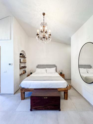 a bedroom with a bed with a mirror and a chandelier at Villa La Petite Etoile in Torre delle Stelle