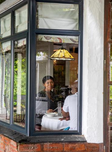 a person sitting at a table in a window at Rawdons Hotel & Brewery in Nottingham Road