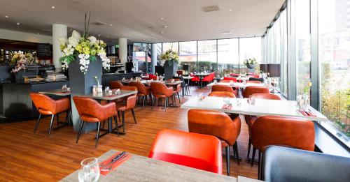 ein Restaurant mit Tischen und Stühlen in einem Zimmer in der Unterkunft Bastion Hotel Zaandam in Zaandam