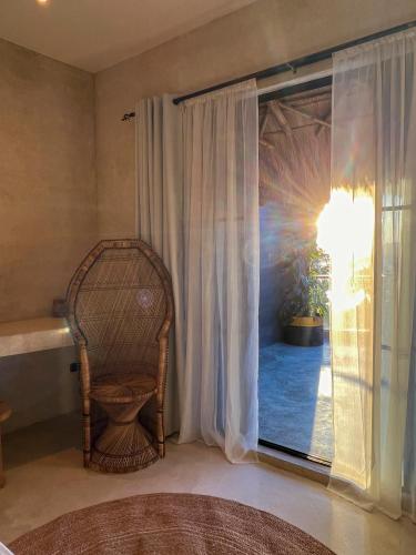a wicker chair sitting in a room with a window at Happiness Kulambo Villa El Nido in El Nido