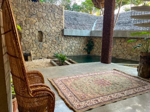a table with a rug and a chair on a patio at Happiness Kulambo Villa El Nido in El Nido